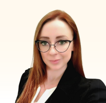 Headshot professional photo of Sanna Westermann, the CEO of Active Reach Consulting. Long redish hair, pale skin, black frame wire cat eye glasses, black blazer and white blouse.